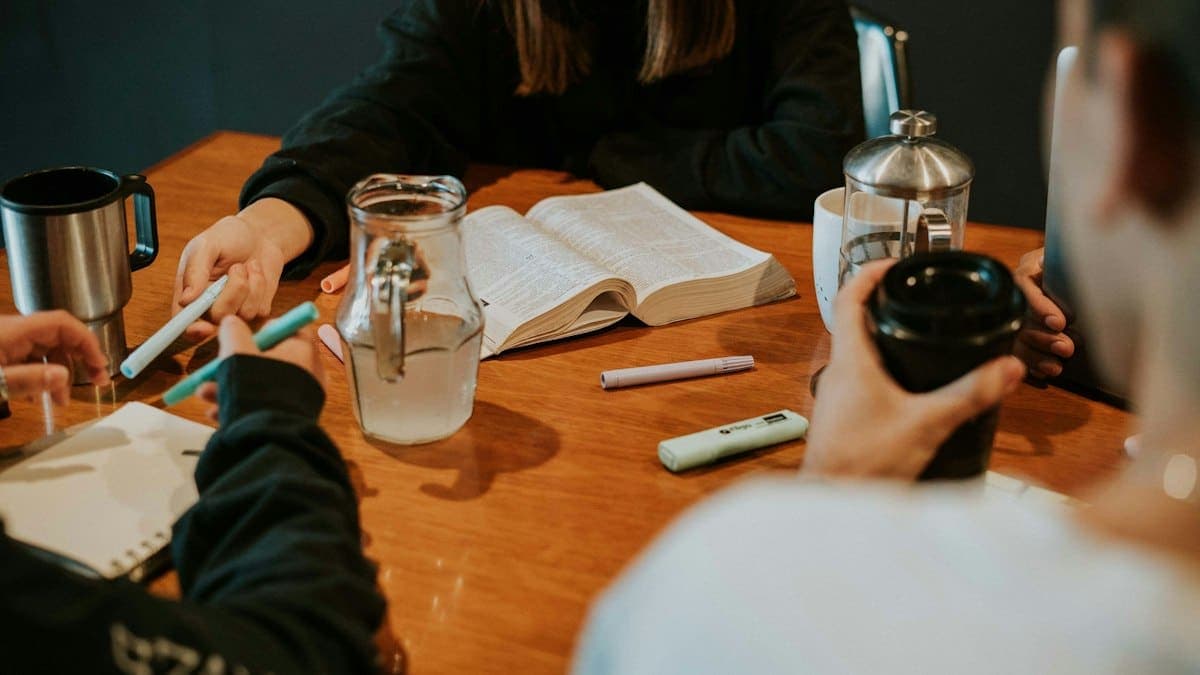 A small group Bible study around a wooden table